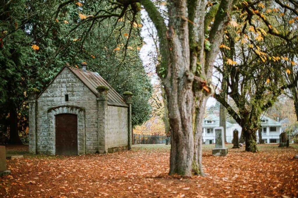 mausoleum amidst trees and autumn leaves at Lone Fir Cemetery