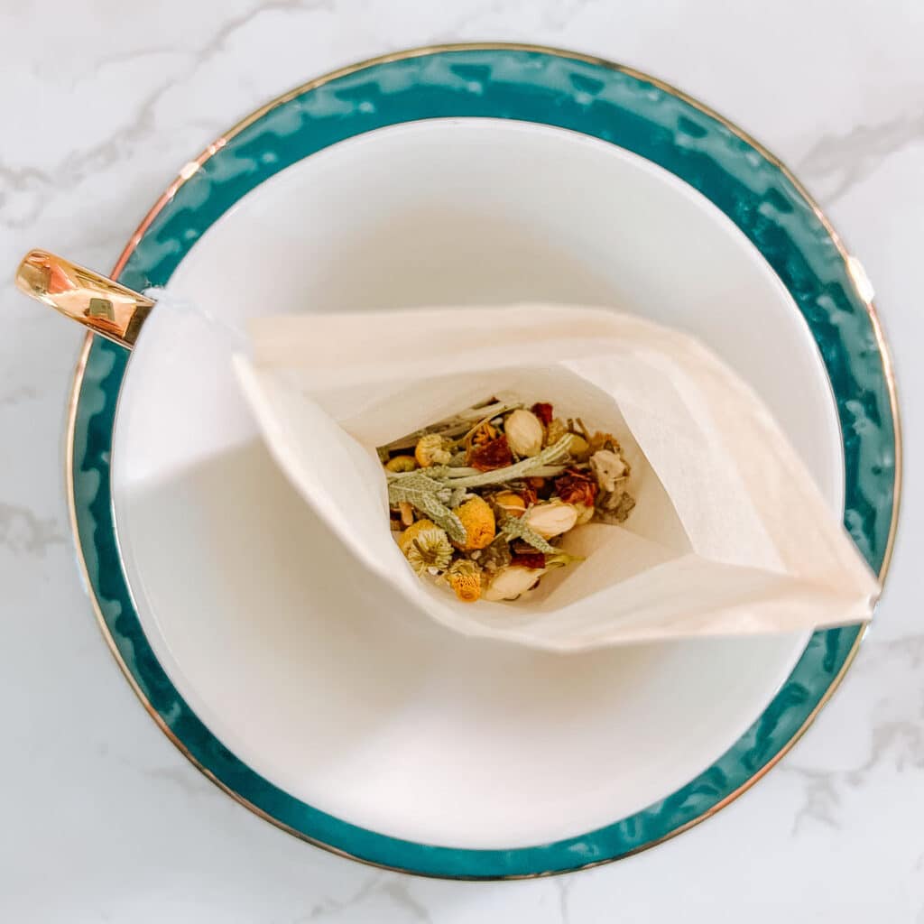 looking into sachet of herbal ingredients in empty teacup