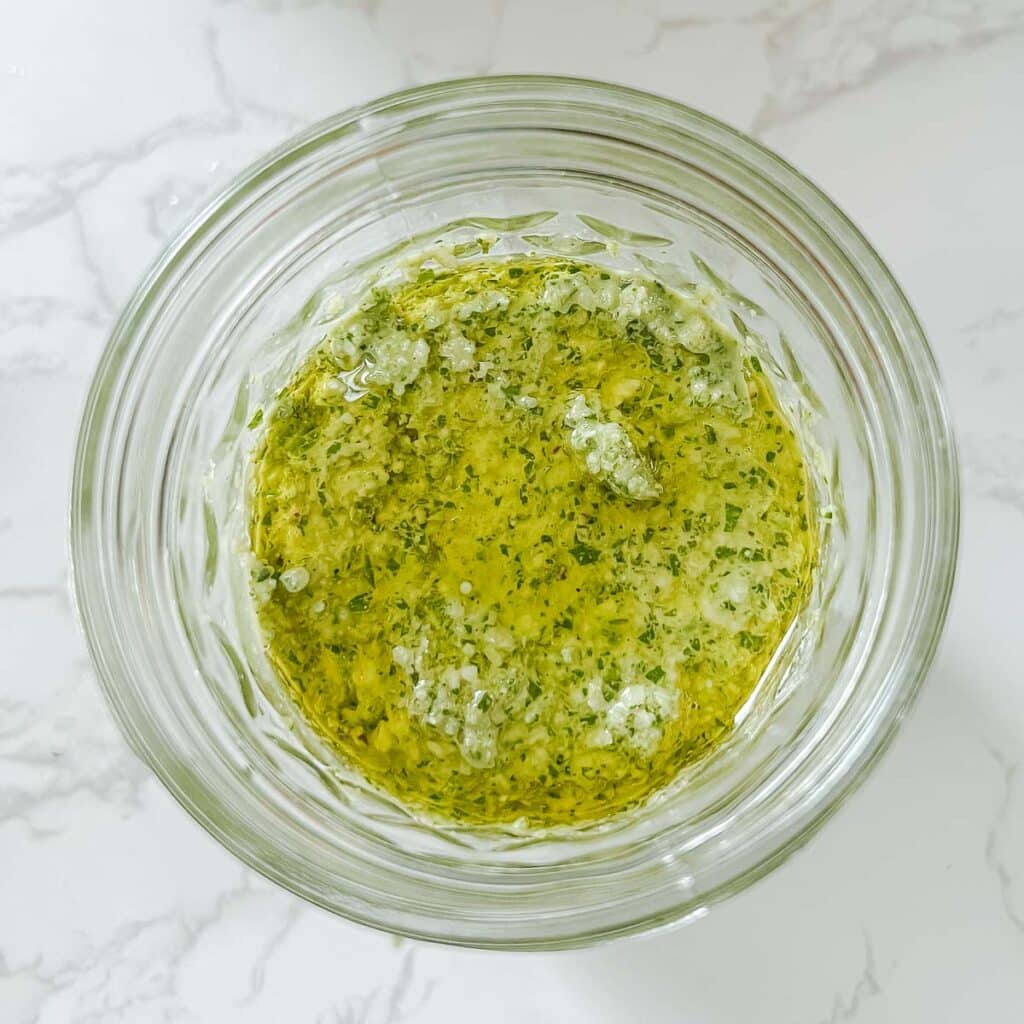 pesto in mason jar with olive oil on top