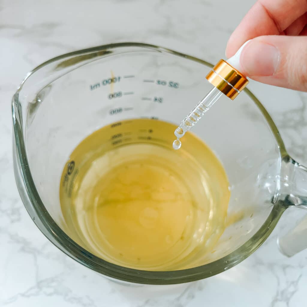 essential oils dropper with drop being added to rosemary water