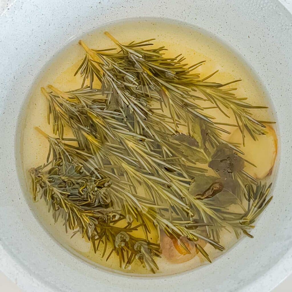 rosemary, ginger, mint in golden-colored water after resting