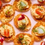 bloody mary deviled eggs with various toppings (olives, pickles, dill, etc.) and flamingo toothpick.