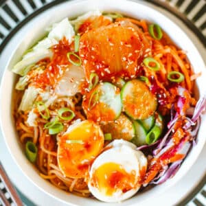 bibimmyeon topped with veggies, sauce, and jammy eggs.