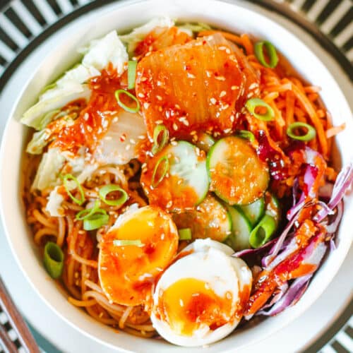 bibimmyeon topped with veggies, sauce, and jammy eggs.