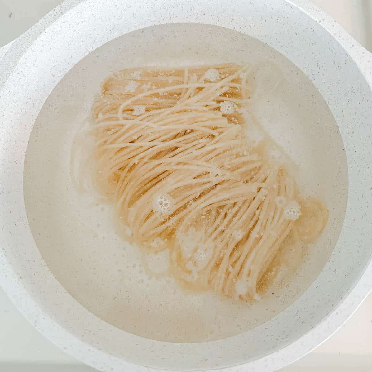 uncooked noodles in a pot of water.