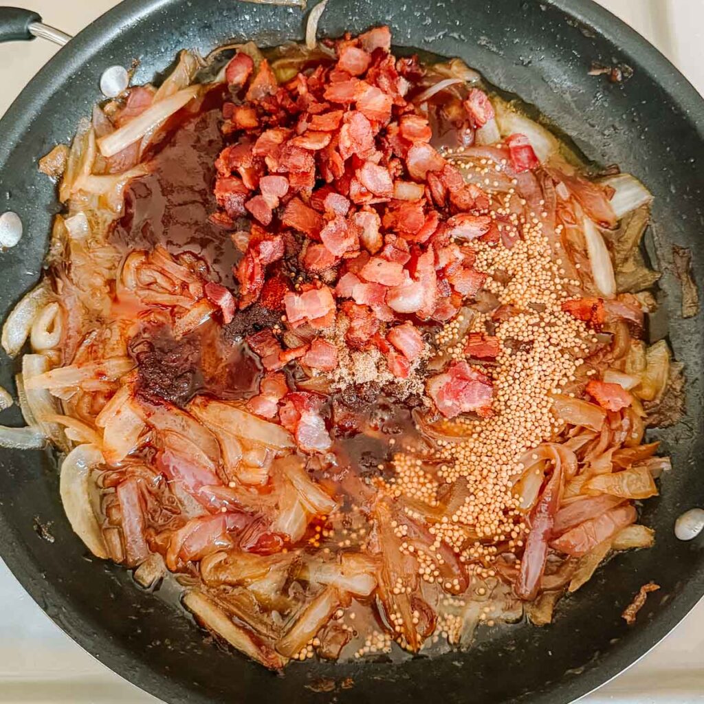caramelized onions topped with bacon, spices, sauces before mixing.