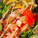 sushi rice bowl topped with masago, sesame seeds, and sauces.