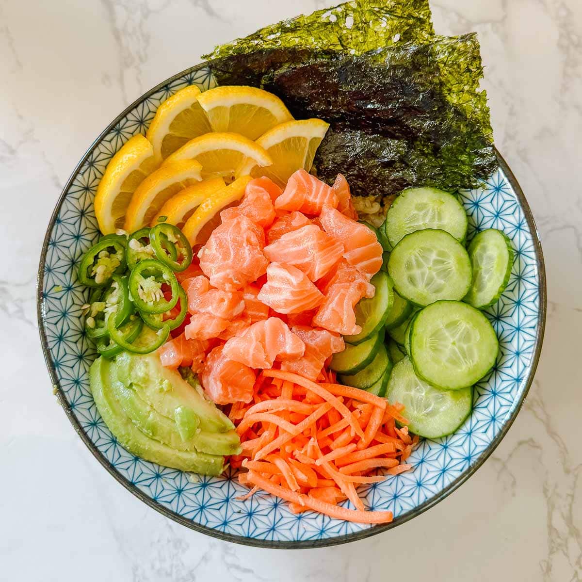 salmon, veggies, nori, and lemon atop sushi rice.