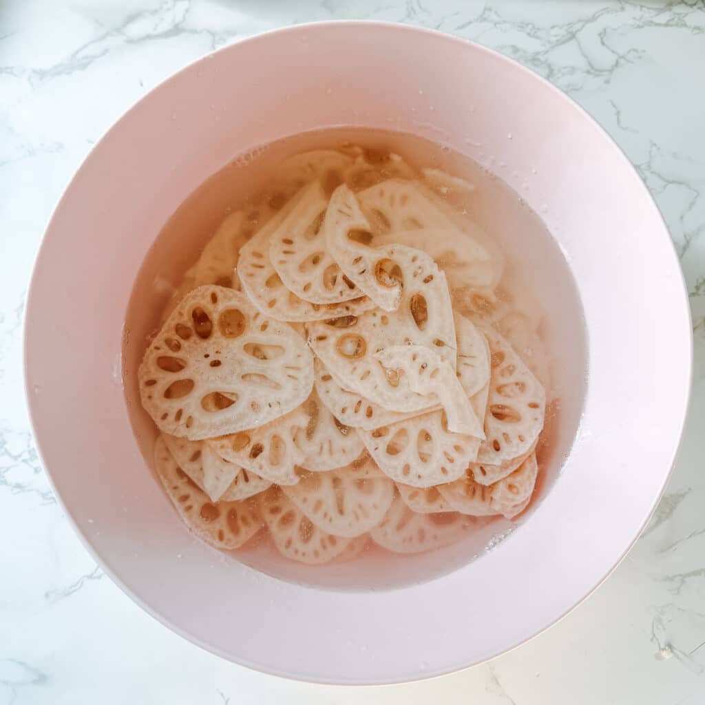 lotus root slices soaking in water and vinegar.