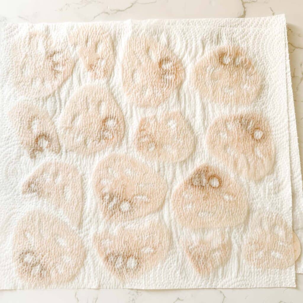 lotus root slices drying between paper towels.