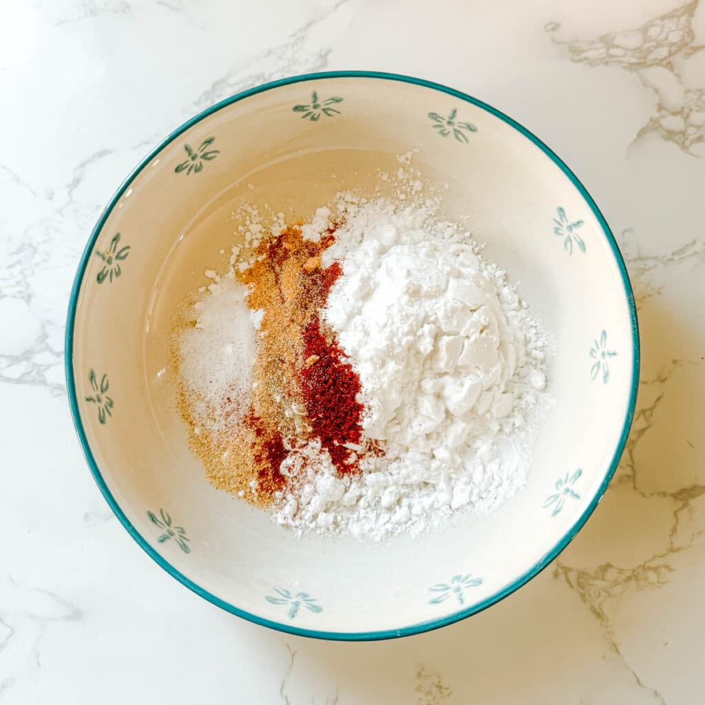 spices and starch in bowl before mixing.