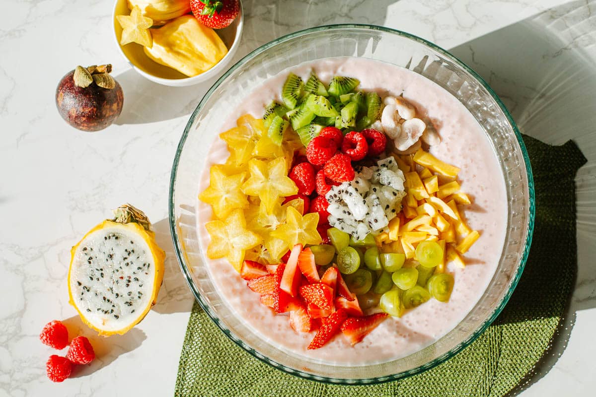 coconut milk sago topped with and surrounded by tropical fruits sucg as dragon fruit, star fruit, mangosteen, jackfruit, etc.